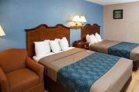 ein Hotelzimmer mit zwei Betten und einem Stuhl in der Unterkunft Econo Lodge Sturbridge Route 20 in Sturbridge