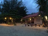 ein Haus mit einer Picknickbank davor in der Unterkunft Red Coral Cottage in Tanjung Rhu