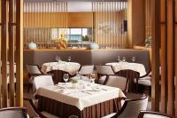 a dining room with tables and chairs and a restaurant at Beijing Hotel Minsk in Minsk