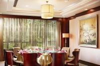 a dining room with a table and chairs and a large window at Beijing Hotel Minsk in Minsk