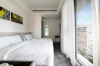 a bedroom with a white bed and a large window at CityInn Hotel Plus- Fuxing North Road Branch in Taipei