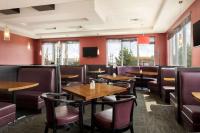 ein Restaurant mit Holztischen und -stühlen und roten Wänden in der Unterkunft Travelodge Hotel by Wyndham Weyburn in Weyburn