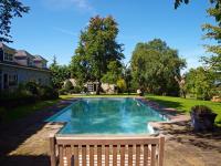 a swimming pool with a bench next to a house at B&amp;B La Buissonniere in Xhoris