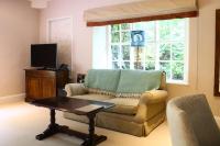 ein Wohnzimmer mit Couch und Fernseher in der Unterkunft Plas Nanteos Mansion in Aberystwyth