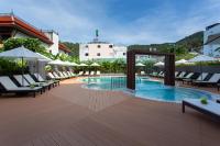 a pool at a hotel with chairs and umbrellas at Krabi Heritage Hotel in Ao Nang Beach