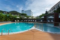 a swimming pool with chairs and umbrellas next to a building at Krabi Heritage Hotel in Ao Nang Beach