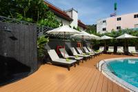 a patio with chairs and a swimming pool with umbrellas at Krabi Heritage Hotel in Ao Nang Beach