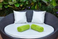 a wicker chair with two lime green towels on it at Krabi Heritage Hotel in Ao Nang Beach