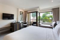 a hotel room with a bed and a balcony at Krabi Heritage Hotel in Ao Nang Beach