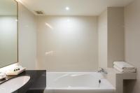 a white bathroom with a tub and a sink at Krabi Heritage Hotel in Ao Nang Beach