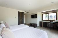 a hotel room with two beds and a desk at Krabi Heritage Hotel in Ao Nang Beach