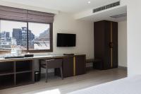 a bedroom with a desk and a large window at Krabi Heritage Hotel in Ao Nang Beach
