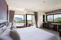 a hotel room with a bed and a desk and windows at Krabi Heritage Hotel in Ao Nang Beach