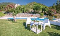 a table and two chairs in the grass by a pool at Finca El Huertezuelo in El Bosque