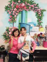 two women are standing in front of areath of flowers at Garden Rose Homestay in Taitung City