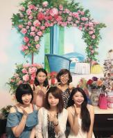 a group of women posing in front of a floral arch at Garden Rose Homestay in Taitung City
