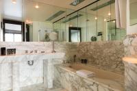 a bathroom with a tub and a sink and a mirror at Hotel Square in Paris