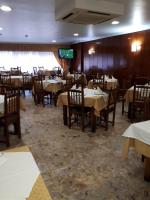 una sala da pranzo con tavoli e sedie e una TV di Hotel 2 de mayo 2 a Xinzo de Limia