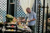 un hombre parado frente a un buffet de comida en La Sinfonía Citadel Hotel and Spa, en Hanói