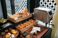 un buffet con varias bandejas de pan y bollería en La Sinfonía Citadel Hotel and Spa, en Hanói