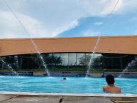 Ein Mann in einem Pool mit einem Brunnen. in der Unterkunft KL Service Suites at Times Square KL in Kuala Lumpur