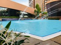 einem großen Pool mit einem Brunnen vor einem Gebäude in der Unterkunft KL Service Suites at Times Square KL in Kuala Lumpur