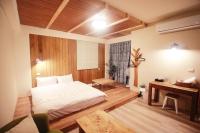 a bedroom with a bed and a desk in it at Hejia B&amp;B in Hualien City