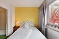 a bedroom with a bed with a yellow wall and a window at Am Neutor Hotel Salzburg Zentrum in Salzburg