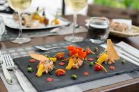 un plato negro de comida en una mesa con copas de vino en Hôtel & Spa du Domaine des Thômeaux, The Originals Relais, en Mosnes