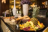 Un buffet con una piña y otras frutas en un mostrador. en Duna Garden Hotel, en Budapest