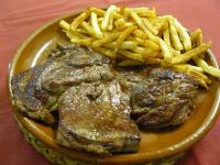 a plate of meat and french fries on a table at Casa Rural, Spa y restaurante El Huerto del Abuelo in Almiruete