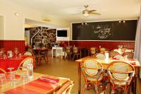 un restaurante con mesas y sillas y una pizarra en la pared en Auberge Le Romarin, en Valgorge