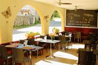un restaurante con mesas y sillas y un menú en Auberge Le Romarin, en Valgorge