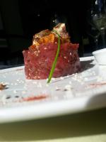 Un trozo de carne con una hoja verde en un plato. en ibis Styles Ancenis Centre, en Ancenis