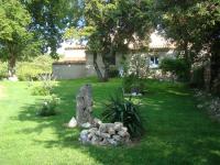 a garden with a rock statue in front of a house at Chambres d&#39;Hôtes de Curnier in Bédoin