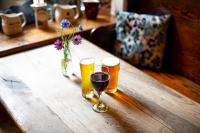 Trengilly Wartha Inn في القسطنطين: كأسين من البيرة يجلسون على طاولة خشبية