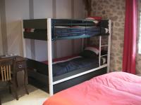 a bedroom with two bunk beds and a desk at Maison Chabrat in Liginiac