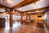 Un comedor con mesas y sillas de madera. en Karczma Karnasów, en Cisna