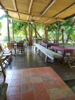 an outdoor patio with tables and chairs and a wooden ceiling at Cenacle B &amp; B in Chenggong