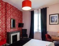 a bedroom with a fireplace and a red wall at Hotel Mirabeau in Tours