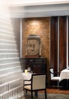 a restaurant with a statue of a head on the wall at Jaya House River Park Hotel in Siem Reap