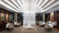 a large glass fountain in the dining room of a restaurant at Jaya House River Park Hotel in Siem Reap