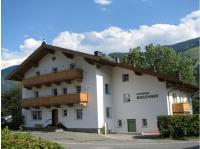 a large white building with a wooden roof at Pension Rosenhof in Brixen im Thale