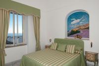 a bedroom with a bed and two windows at Casa Teresa in Positano
