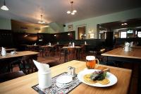 a restaurant with a plate of food on a table at Hotel Valcha in Prague