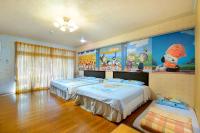 a bedroom with two beds and a painting on the wall at Jinge Guest House in Jiji