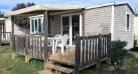 Cette petite maison dispose d&#39;une terrasse avec une table et des chaises. dans l&#39;établissement Camping La Prairie, au Muy