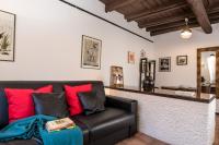 sala de estar con sofá de cuero negro y almohadas rojas en Al Cedro, en Roma