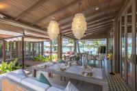ein Esszimmer mit Tisch und Stühlen und Kronleuchtern in der Unterkunft Cape Fahn Hotel - Private Islands Samui in Strand Choeng Mon