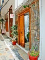 un edificio con una puerta de madera y macetas en el exterior en Glaros Guesthouse, en Hydra